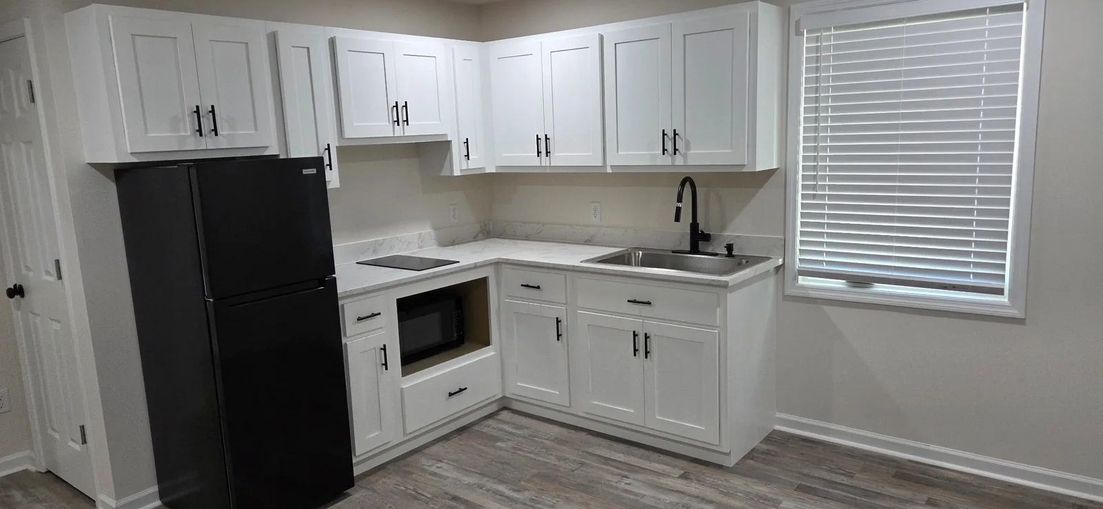A renovated Marlboro kitchen with white shaker cabinets, refrigerator, cooktop and microwave.