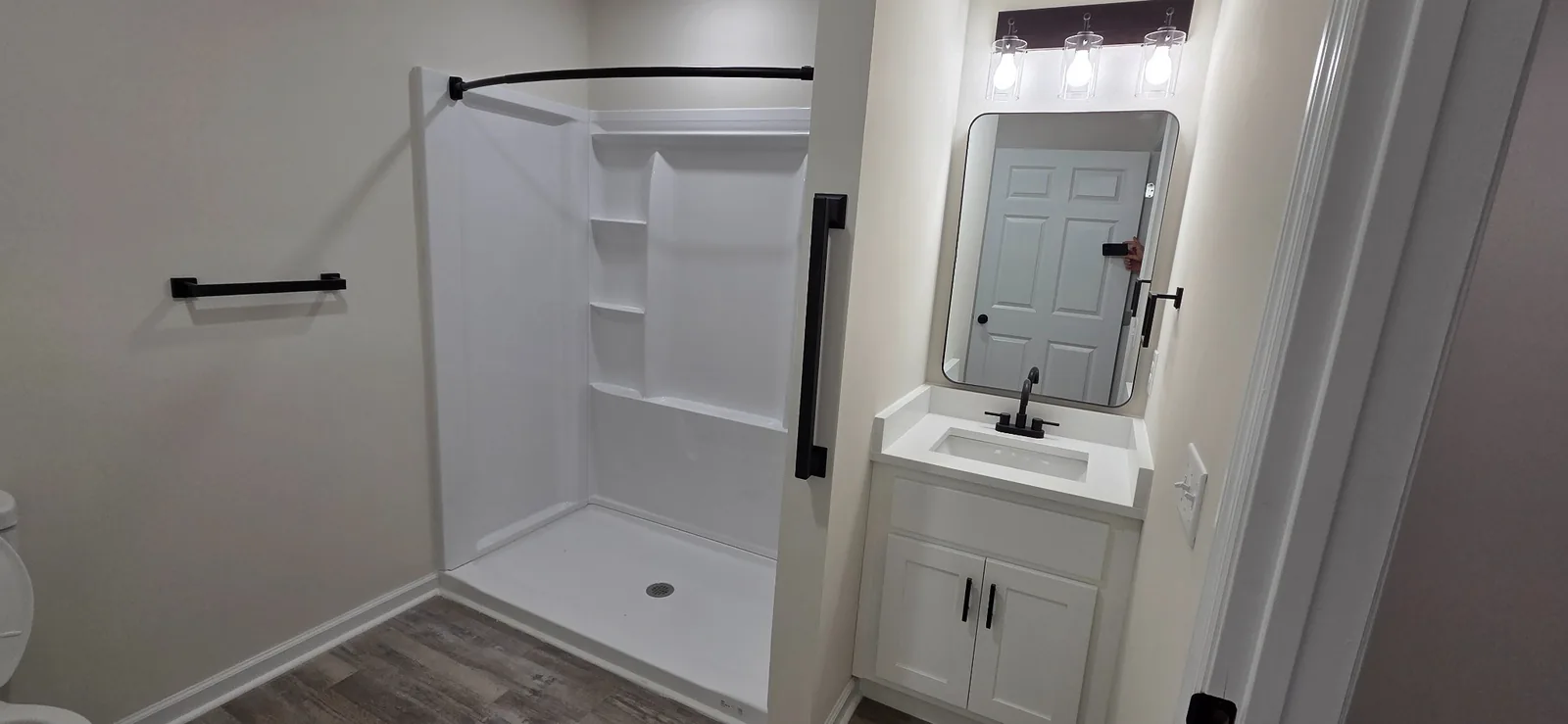 Marlboro bathroom vanity with a black-framed mirror beside the walk-in shower.
