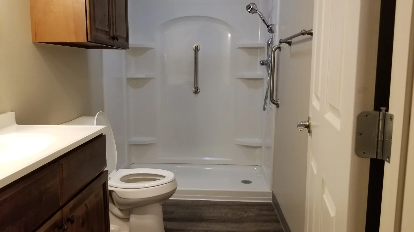 Accessible bathroom with a step-in shower, grab bars and a fold-down seat.