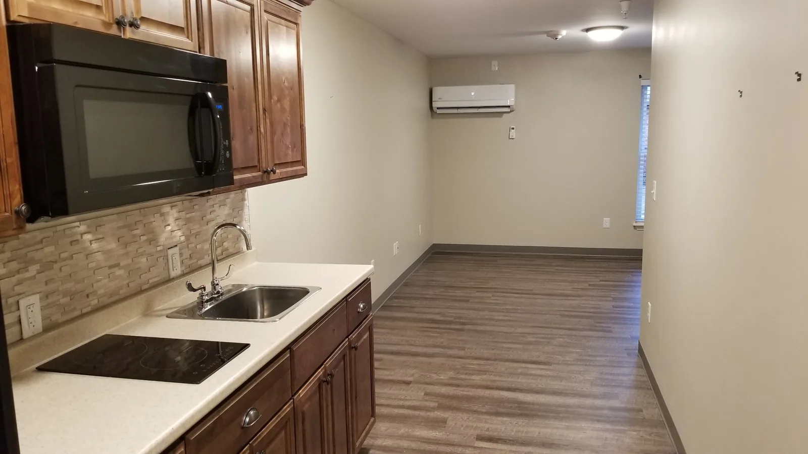 Open kitchen and living area in a Silverdale apartment with a wall-mounted mini-split unit.